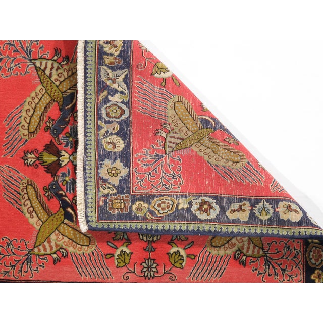 Vintage hand-knotted Persian Qom wool rug on a silk foundation, featuring a coral field with a central floral medallion...