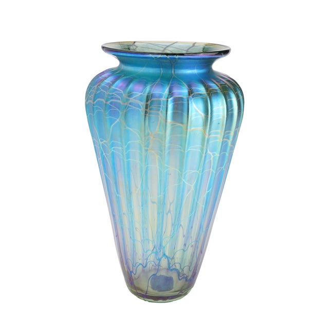 An iridescent blown glass vase by Manhattan Beach, California glass artist Mayauel Ward. The tapered, fluted body sits on...