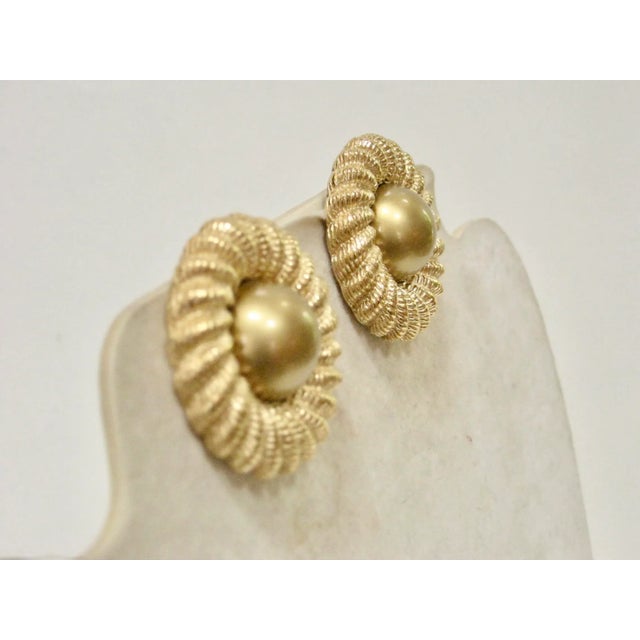 This is part of Chairish’s Costume Jewelry assortment. Classic vintage Richelieu sunburst carved gold clip back earrings....