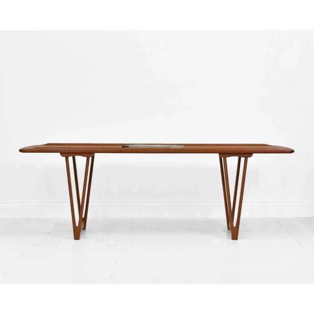 A mid-century Danish teak coffee table attributed to Andreas Hansen. Circa 1960. This stylish design table stands on...
