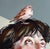 This artwork features a contemplative figure gazing upward, embodying a serene yet introspective mood. A small bird...