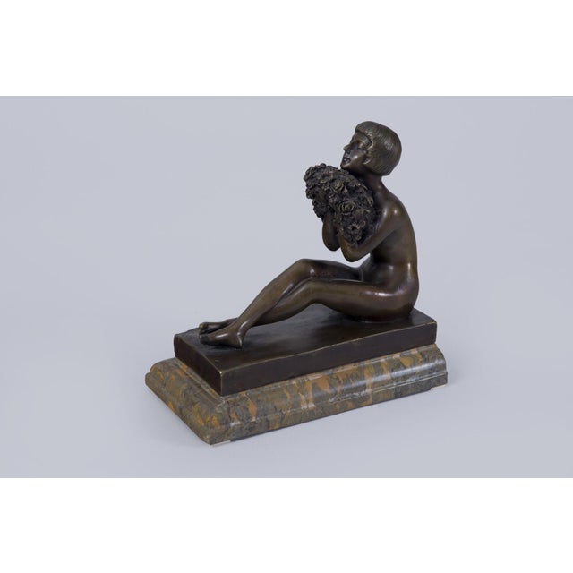 This impressive sculpture titled "Girl with Flowers" dates back to the 1920s, was created in France, and represents an...