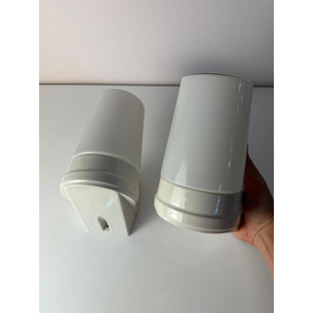 A stylish duo for your home: this set of two wall lamps, model 6070, in timeless white, designed by sigvard bernadotte for...
