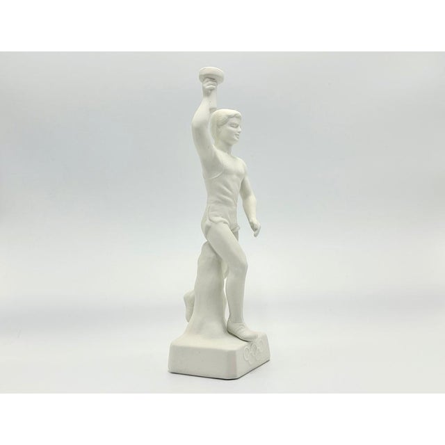 A souvenir from the 1936 Olympic Games. Statue is made out of fine white bisque, the base bears the Olympic Rings, is...