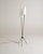 Two black-painted metal stems extend from a tripod base and terminate at different heights in conical white fabric...