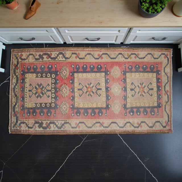 This charming hand-knotted Oushak rug features a beautifully weathered aesthetic with soft, sun-faded tones that bring a...
