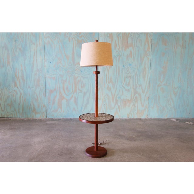 A 1960s floor lamp with integrated tile table top designed by Jane and Gordon Martz for Marshall Studios. Labeled with a...