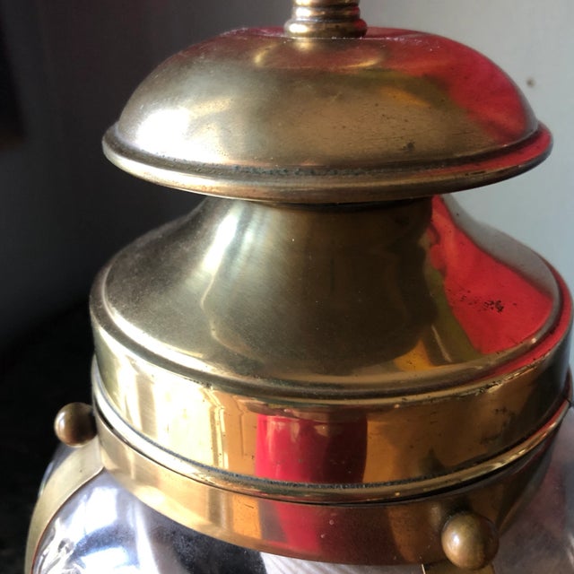 Beautiful glass vase adorned with brass filled with nautical shells. Perfect for bookcase or table display in any room or...
