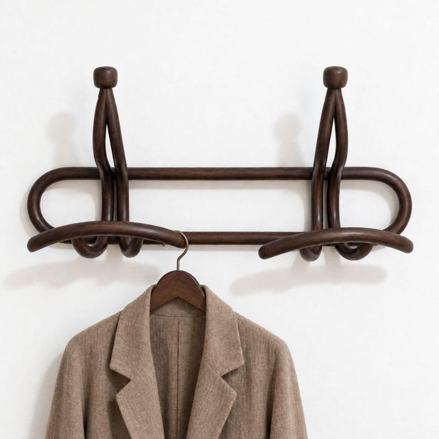 A refined Italian wall-mounted coat rack from the early 20th century, crafted from walnut and featuring an elegant Art...