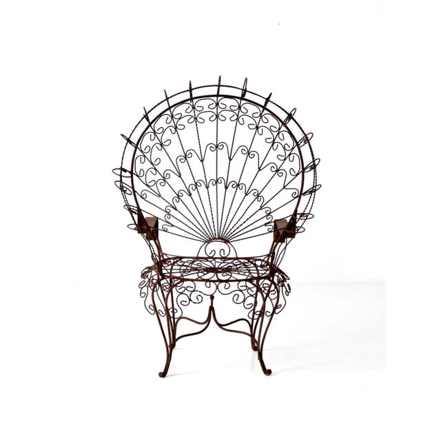 This monumental vintage wrought iron peacock chair commands attention with its dramatic fan-shaped back and intricate lacy...