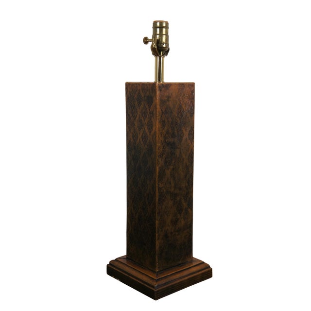 Late 20th century Sarreid, Ltd embossed brown leather table lamp. Square column form with step base, embosses with a...