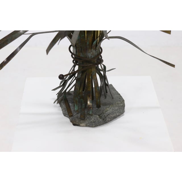 unusual sculptural vase from the 1970s. The piece has a granite base and holds a brass vessel which is decorated with...