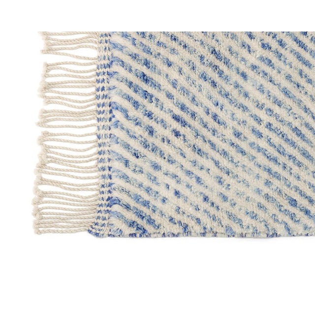 A hypnotic weave of diamonds, radiating outward like ripples on water. This hand-knotted wool rug builds a mesmerizing...