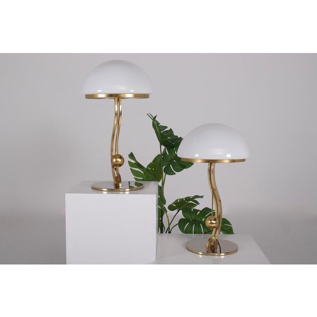 Table lamps in brass and gilded steel, imitating a tilting pendulum. They are covered with an opaline glass dome enclosing...