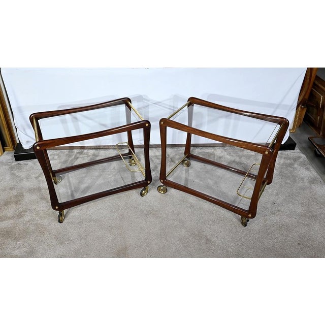 Rolling tables composed of two glass plates, 6mm thick, held by two side frames in solid mahogany. These frames are...