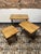 A stylish set of three vintage industrial nesting tables, each featuring a sturdy wrought iron base paired with plain oak...