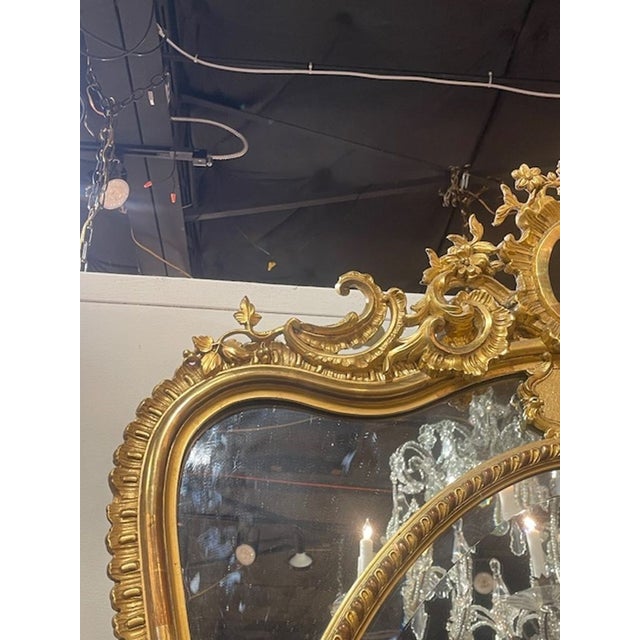 This Antique French Louis XV Shaped Giltwood Mirror is a luxurious and elegant addition to any home décor. This mirror,...