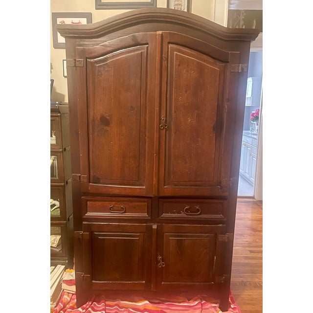 Substantial Mexican pine armoire in the Spanish Colonial/Hacienda tradition, featuring a rich dark-stained finish,...