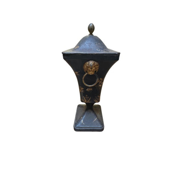 Beautiful 19th century tole urn with golf leaf and floral designs with lion head door knocker handles and an oval finial...