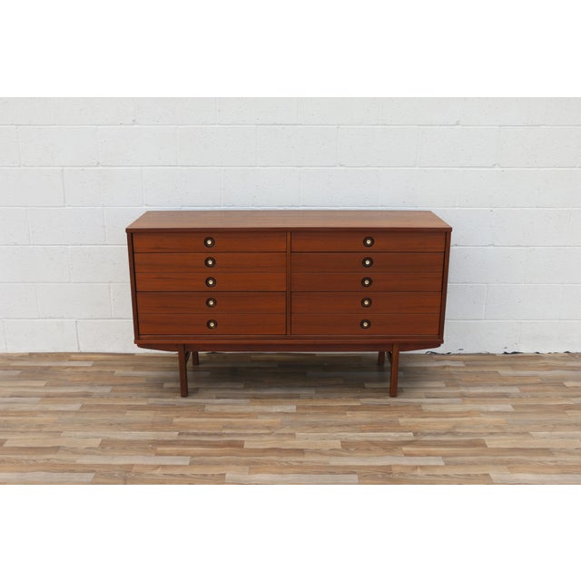 An elegant example of American Mid-Century Modern design, this six-drawer walnut dresser by United Furniture, circa 1960s,...