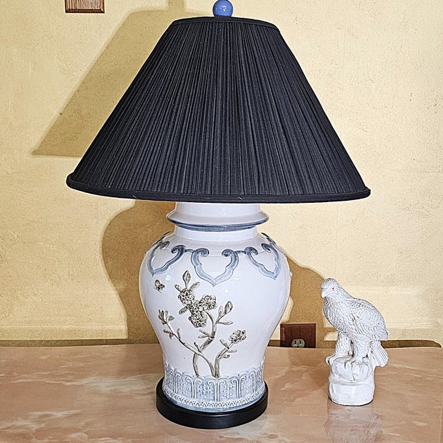 A beautifully crafted Chinese Chinoiserie style porcelain table lamp featuring a hand-painted and raised floral motif in...
