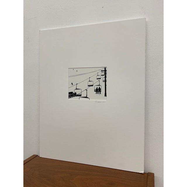 A black and white print depicting a ski lift scene with silhouetted figures ascending a snowy slope. The composition...