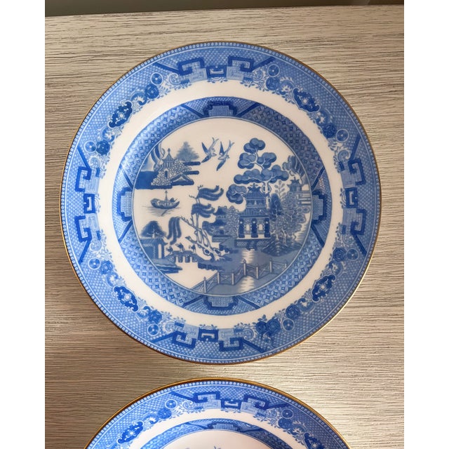 A classic and beautifully detailed pair of Minton Blue Willow plates, featuring crisp cobalt transferware imagery and a...