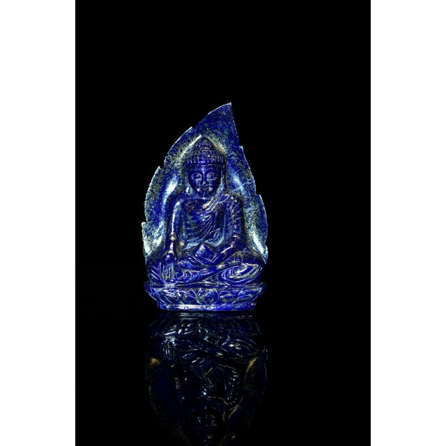 A beautiful hand-carved Indian Buddha sculpture in natural lapis lazuli. Buddha is seated dhyana asana, with softly...