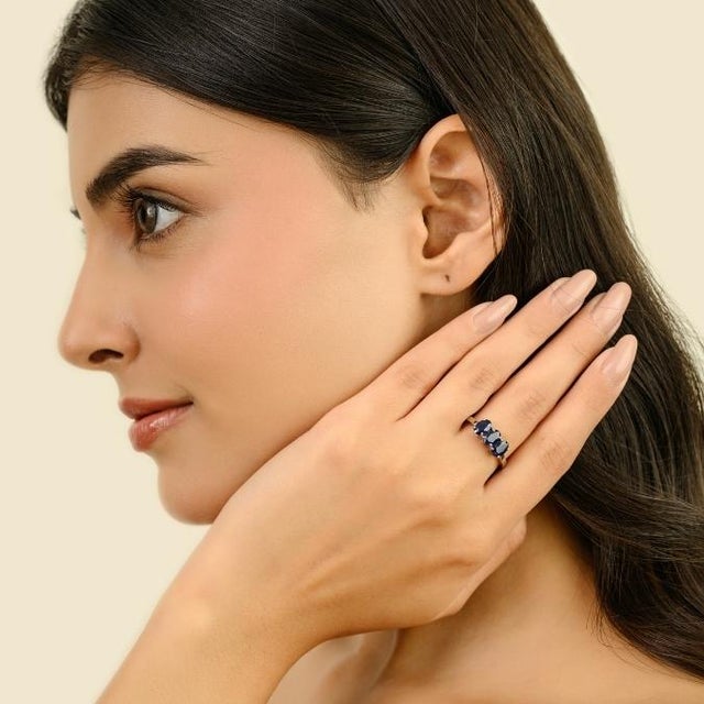 This elegant modern three-stone ring features 3 oval cut natural blue sapphires totaling 2 carats, set in rich 14k white...