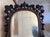 This 20th century French mirror is set within a rectangular carved Black Forest style crested wooden frame. The intricate...