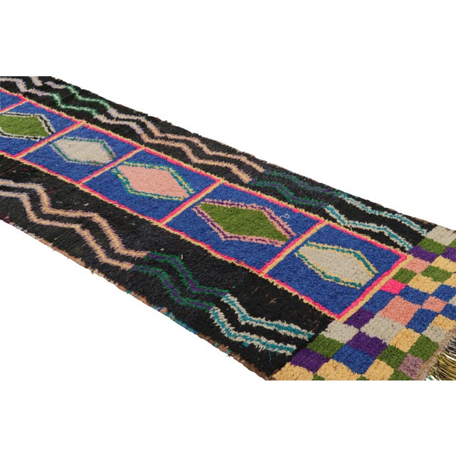 Hand-knotted in wool and originating from Morocco circa 1950-1960, this 3x10 vintage Moroccan rug is an extremely rare...