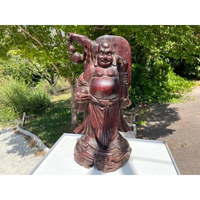 We have a very nice wooden Buddha sculpture. It dates from the early 20th century, and you can see the aging in its...