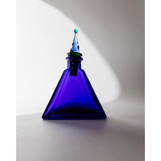 This vintage Murano glass decanter from the 1960s is a striking piece of Italian art glass, crafted in a rich royal blue...