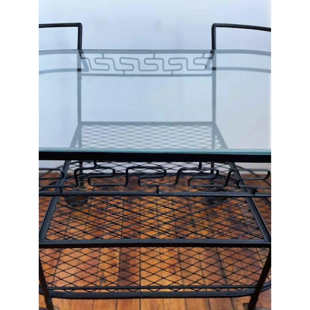 Vintage iron and glass three tiered, rolling serving cart. Wrought iron and iron with glass top shelf, square middle shelf...