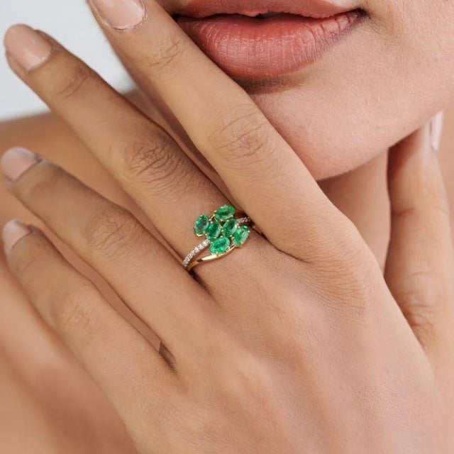 This vintage-style cluster cocktail ring features 1.37 ct of oval-cut green emeralds, set in 14k yellow gold. Each emerald...