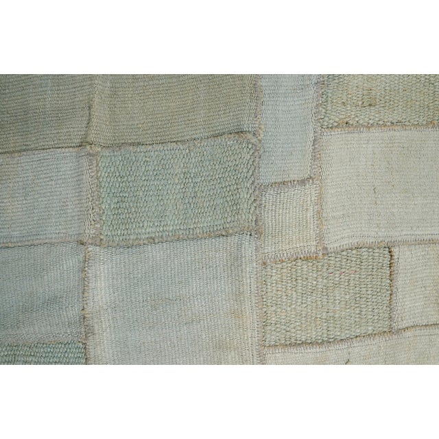 This is a vintage Turkish Oushak rug from the Mid 20th Century. The piece was hand-knotted.