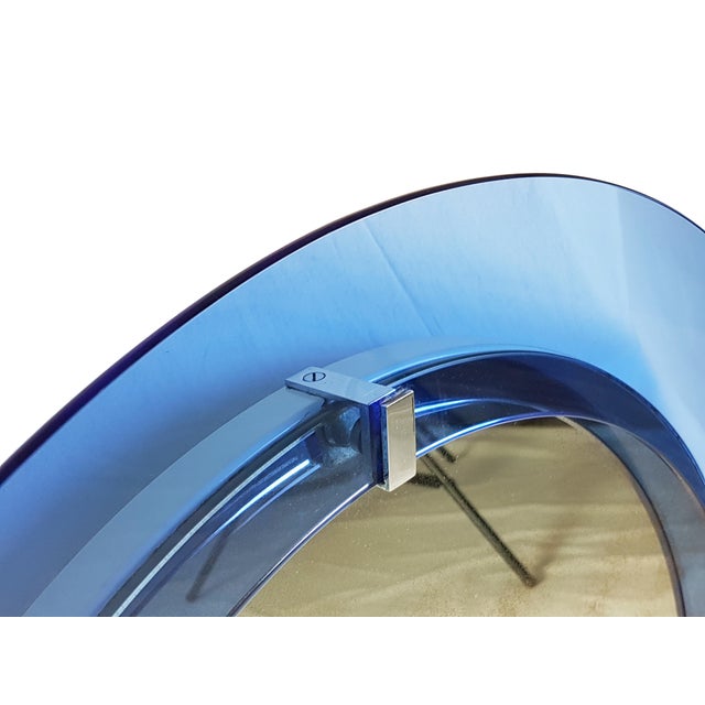 This beautifull and fine wall mirror is made from a convex blue glass frame connected to the main body through 4 chrome-...