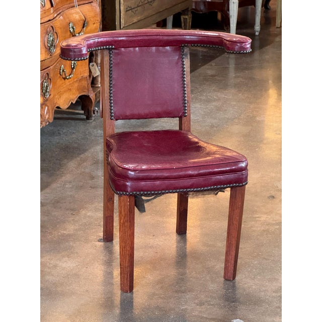 An English cock fighting chair, also referred to as a reading chair, the low mahogany frame designed to be sat astride,...