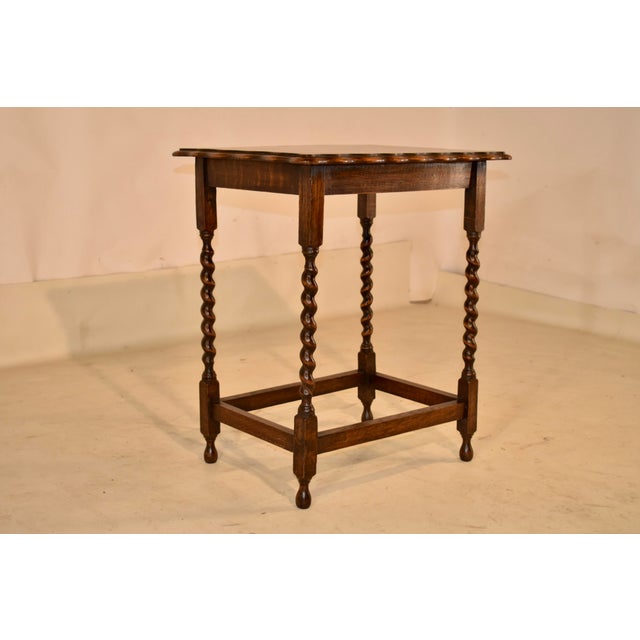 Period Edwardian oak side table from England. The top is nicely grained and has a scalloped and beveled around the edges....