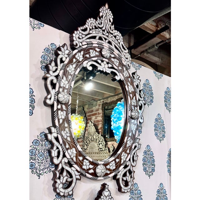 A rare and unusual find, this vintage handcrafted oval mirror features exquisite mother-of-pearl inlay set into natural...