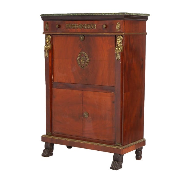 An antique French Empire abattant secretary offers flame mahogany construction with upper drawer over drop front desk...