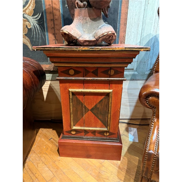 Add bold character and architectural charm to your space with this antique painted wood pedestal stand featuring a...