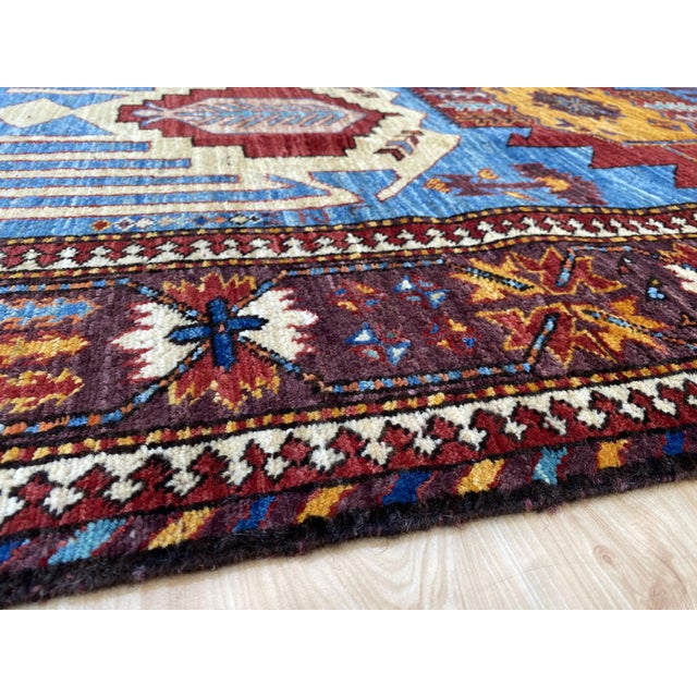 Karachov Kazak design rug, hand-knotted in 100% wool with a dense, plush pile. Cornflower blue field with six bold...