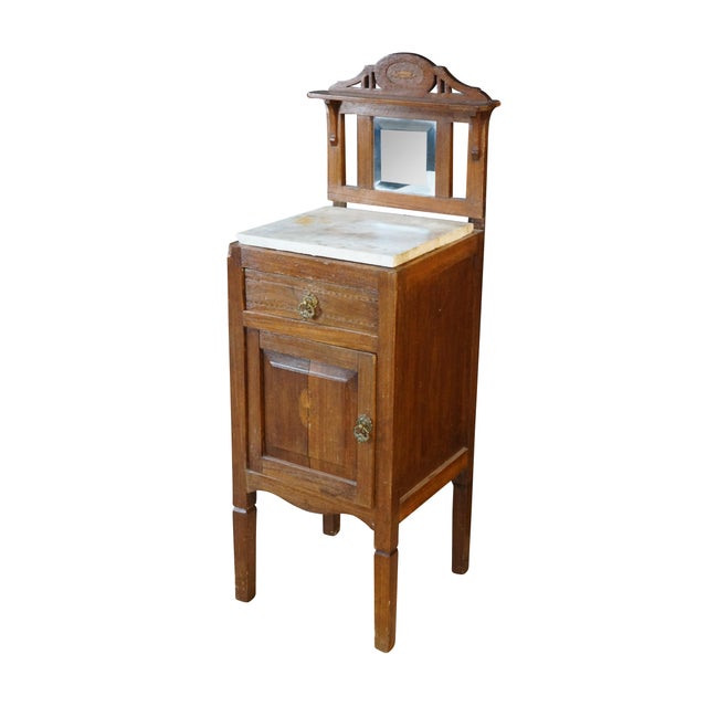 This antique Edwardian washstand features a warm walnut wood grain accented by delicate neoclassical inlay work along the...