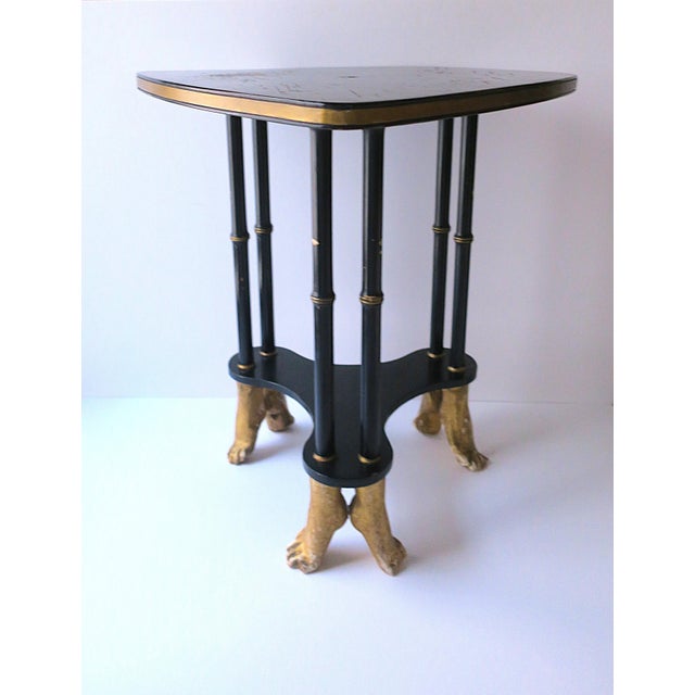 A black and gold side or end table, in the Surrealist design style, circa late-20th century. Table has a guitar-pic shaped...
