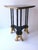 A black and gold side or end table, in the Surrealist design style, circa late-20th century. Table has a guitar-pic shaped...