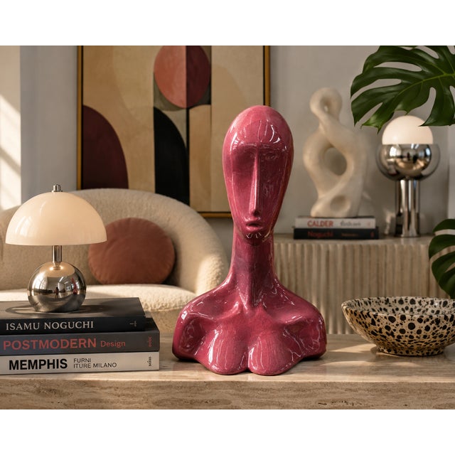 A striking modernist ceramic sculpture featuring an elongated abstract female bust rendered in a rich rose-red high-gloss...