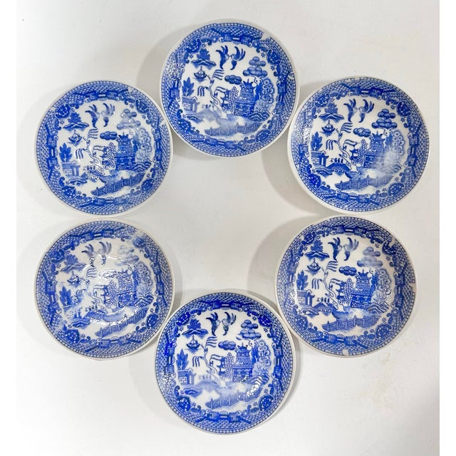 A charming set of six vintage blue and white willow butter pat plates featuring the classic chinoiserie landscape motif...