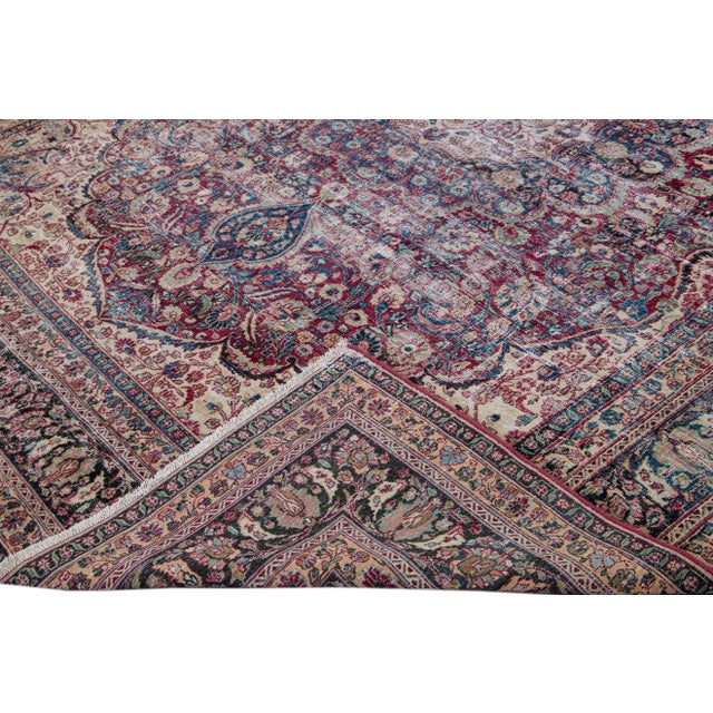 Beautiful vintage distressed medallion hand-knotted wool rug with a red field. This rug has blue, ivory, and green accents...