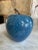 Bright blue marble apple paper weight with a stem.